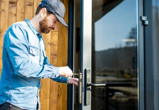 A technician installs a smart lock system