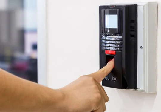 Someone using a fingerprint reader to unlock a door